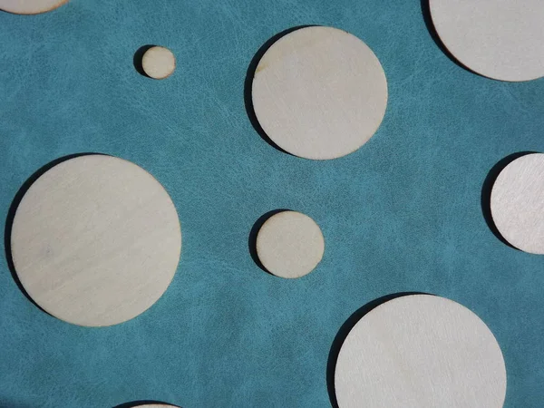 wooden circles of different diameters on blue suede