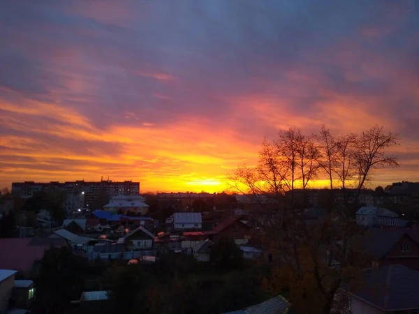 Красивий захід сонця в місті з важкими помаранчевими хмарами — стокове фото