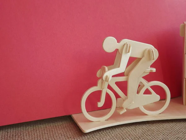 Radfahrer auf einem Fahrrad aus Holz auf rosa Hintergrund — Stockfoto