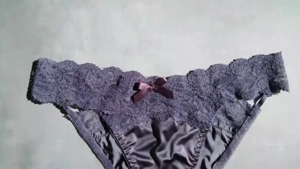 Biru gelap erotis celana dalam terbuat dari sutra dan guipure close-up pada latar belakang abu-abu — Stok Video