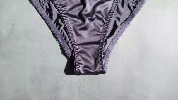 Dark blue erotic panties made of silk and guipure close-up on a gray background — Stock Video