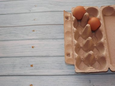 bej tavuk yumurtaları açık ahşap bir arka planda yumurta kutusunda