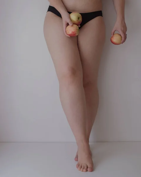 黒の下着を着た女性の足にリンゴをつけて — ストック写真