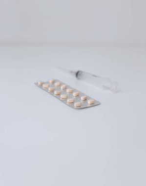 Şırınga ve haplar masanın üstünde.