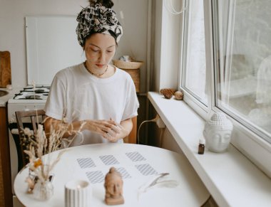Beyaz mutfakta tarot kartları olan kadın.