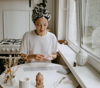 Beyaz mutfakta tarot kartları olan kadın.