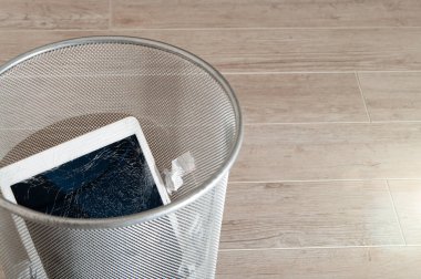 Çöp kutusunda son derece kırık ekranı olan modern tablet.