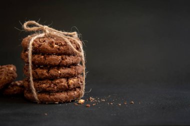 Siyah arka planda ev yapımı çikolatalı kurabiyeler yığını.