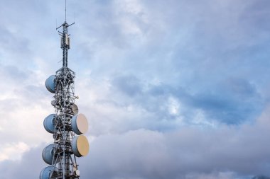 Telekomünikasyon, televizyon ve radyo antenleri bulutlu dramatik bir gökyüzü üzerinde izole edildi. sanayi ve iletişim konsepti.