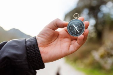 Elinde pusula tutan tanınmayan bir yürüyüşçü. Dağda rehberlik edin. açık hava aktiviteleri.