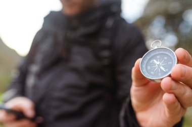 Elinde pusula tutan tanınmayan bir yürüyüşçü. Dağda rehberlik edin. Açık hava aktiviteleri. Seçici odak.