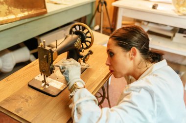 concentrated latin woman painting and restoring an antique. person working in her workshop.