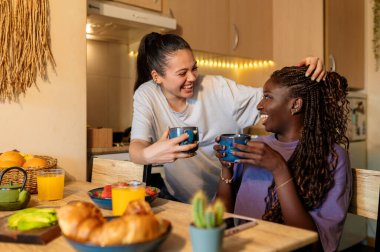 İki kadın, kahvaltının keyfini çıkarıyorlar. Kahkahalarını ve sevgilerini kahve, kruvasan ve taze meyve eşliğinde paylaşıyorlar.