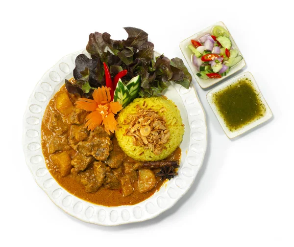 Beef Curry Massaman with Biryani Rice ontop Crispy Onion Asian Food Halal muslim Style inside dish with Ar Jad (cucumber, onio,chili in Vinegar),chili mint sauce decorate Vegetable topview
