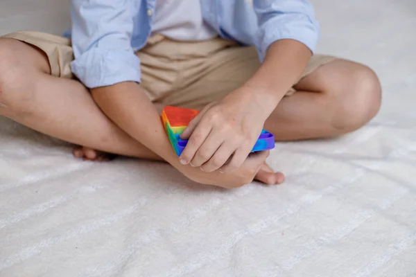 Το αγόρι κρατάει ένα παιχνίδι στα χέρια του. Ευέλικτο παιχνίδι αφής με φούσκα ώθησης antistress — Φωτογραφία Αρχείου