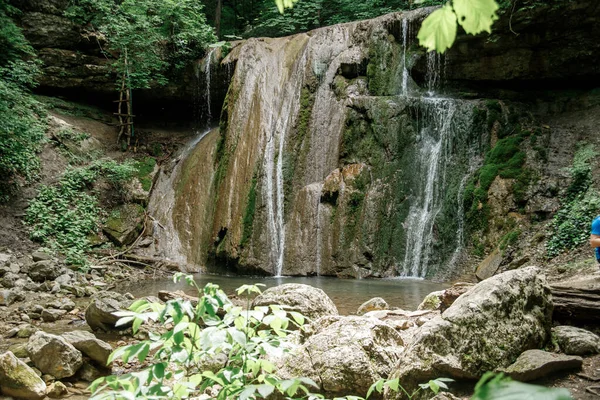 Küçük orman şelalesi. Kayalardan süzülen su püskürtüleri