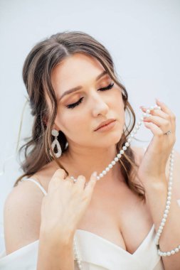 Gelinlikli esmer kız. Beyaz elbiseli gelin. Makyaj.