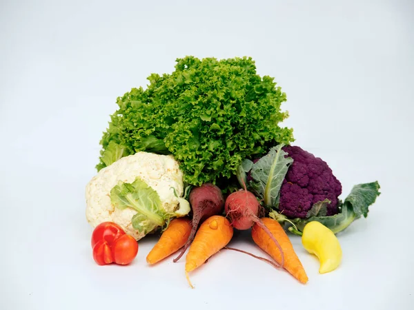 Свежие овощи, морковь, чеснок, зеленый перец, цветная капуста и салат помещены на легкий фон — стоковое фото