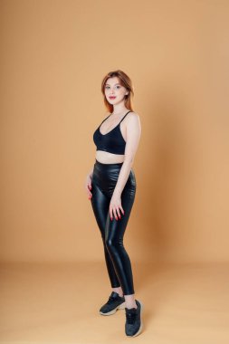 Spor kıyafetli esmer kız bej arka planda spor yapmaya gider..