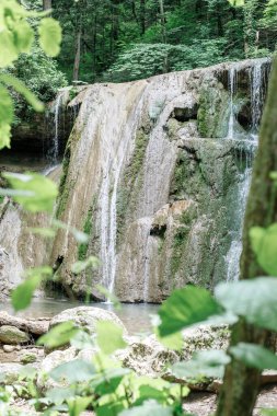 Küçük orman şelalesi. Kayalardan süzülen su püskürtüleri