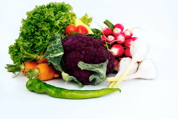 Свежие овощи, морковь, чеснок, зеленый перец, цветная капуста и салат помещены на легкий фон — стоковое фото