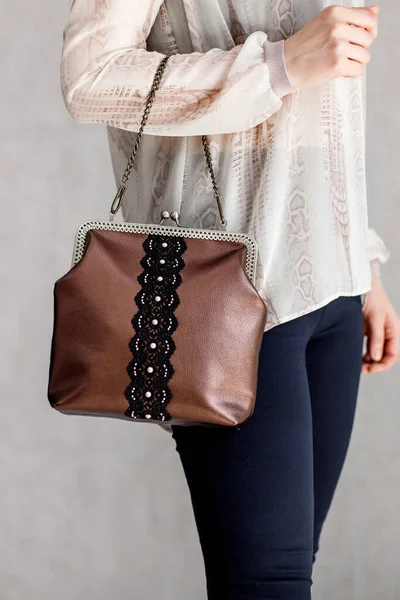 A girl in black pants and a white blouse with a handbag over her shoulder. — Stock Photo, Image