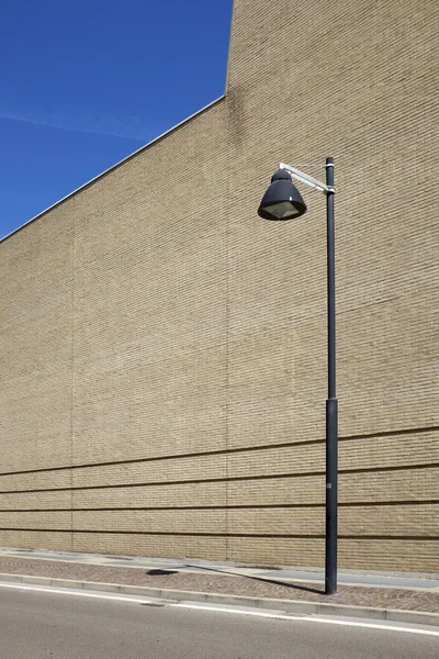 Parede de pedra com poste de luz — Fotografia de Stock