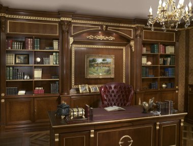 Boiserie duvarı, kitaplığı ve masası olan bir çalışma odasının tek çekim fotoğrafı.