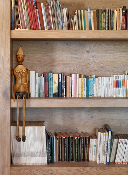 Mensola libreria con burattino Pinocchio — Foto Stock