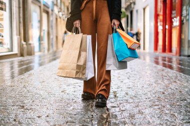 Yüz maskesi takmış, sokakta renkli alışveriş yapan tanınmayan bir kadın..