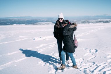 Dağda karda yürüyen iki arkadaş..