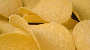 Yavaş çekim kamerası altın patates cipslerinin üzerinde ilerler.