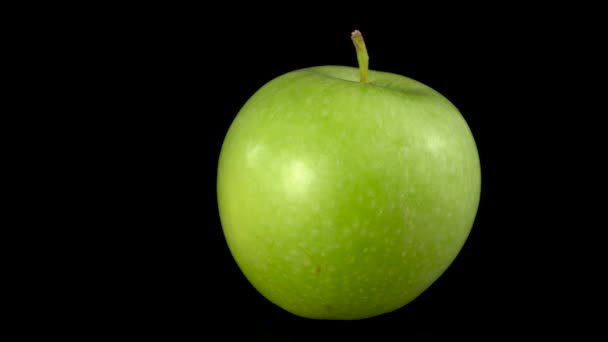 Grüner Apfel rotiert. Nahaufnahme frischer Grüner Apfel auf Schwarz — Stockvideo