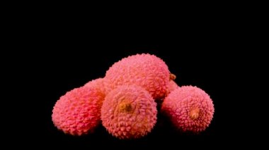 Siyah arkaplanda taze kırmızı Litchi dönüşümlü izole edildi. Üç Raw Litchi