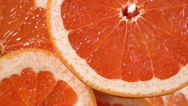 Naranja fresco en rodajas girando sobre fondo de fruta. Vista superior — Vídeos de Stock