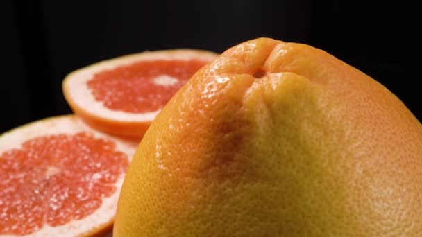 Rotační krájené červené grapefruit izolované na černém pozadí — Stock video