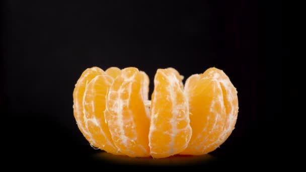 皮をむいたオレンジのスライスは葉なしで回転します。新鮮な柑橘系のみかんのマクロ — ストック動画