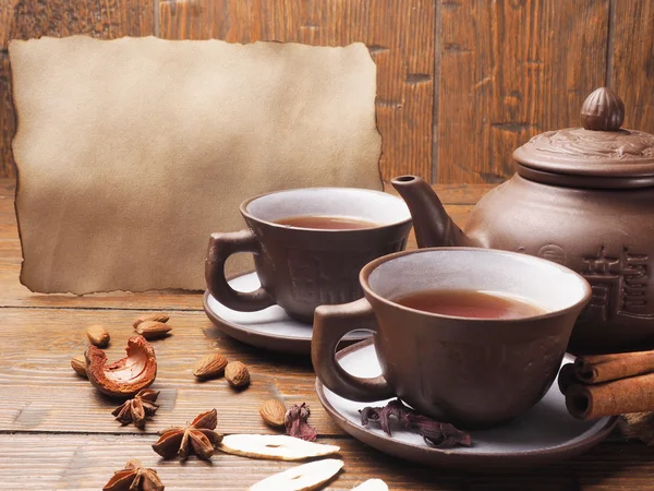 Papel velho e conjunto de chá em um fundo de madeira — Fotografia de Stock