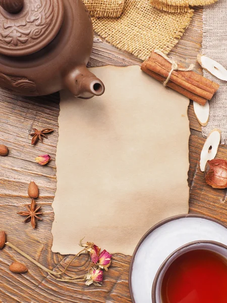 Old paper and tea set on a wooden background — Stock Photo, Image