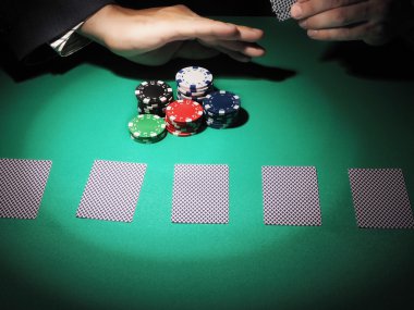 Adam yeşil arka plan üzerinde poker oynamaya.