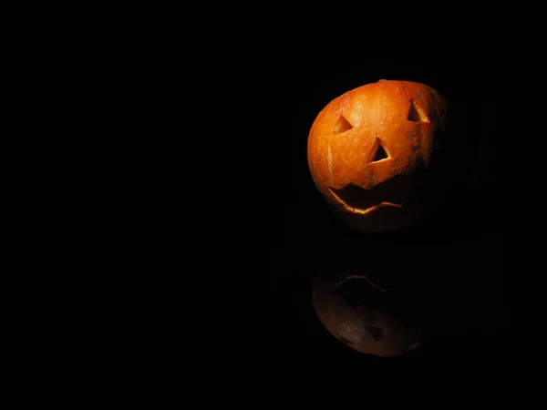 Halloween dýně na černém pozadí s odleskem — Stock fotografie