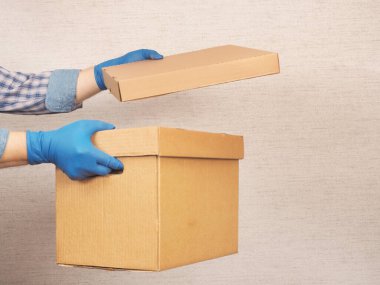 Güvenli teslimat. Tıbbi koruyucu eldivenli eller..