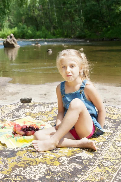 Smiling  girl having picknick on the riverside — Stock Photo, Image