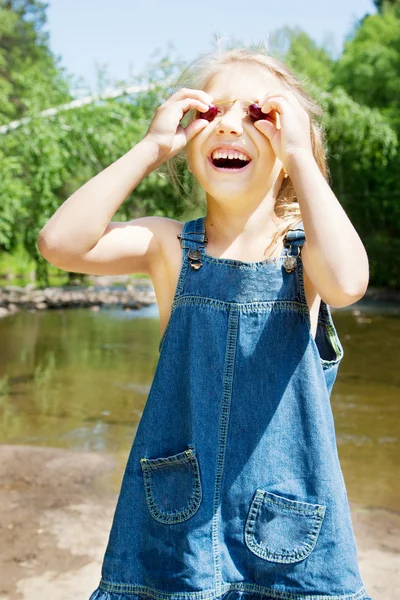 Sonriente chica teniendo picknick en la orilla del río — Foto de Stock
