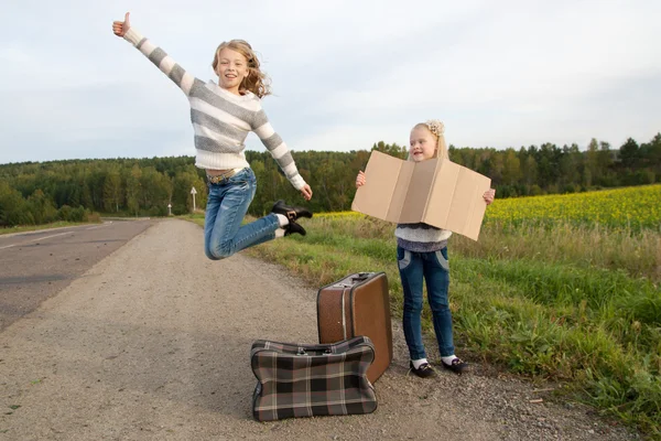 道についてのスーツケースに立って 2 人の女の子 — ストック写真