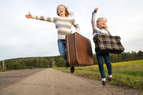 道についてのスーツケースに立って 2 人の女の子 — ストック写真
