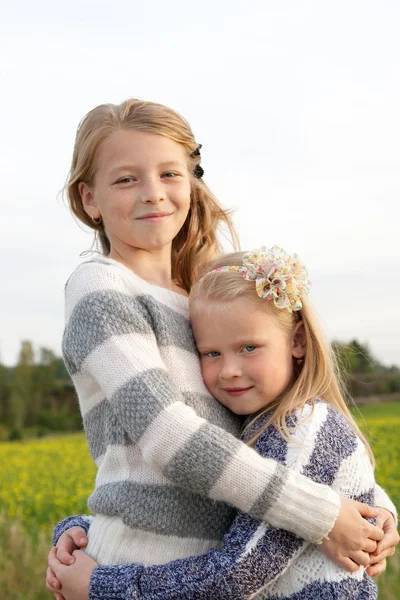 Portret van twee schattige kleine meisjes omarmen — Stockfoto