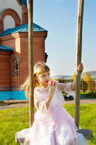 Girl with curly hair wearing  having fun on a swing — Stock Photo, Image