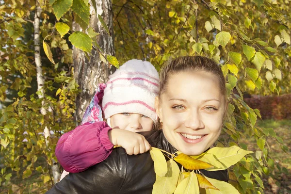 Young mother and her  girl in autumn — Stock Photo, Image