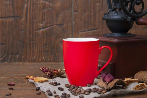 Rote Tasse und Mühle auf Holzgrund — Stockfoto